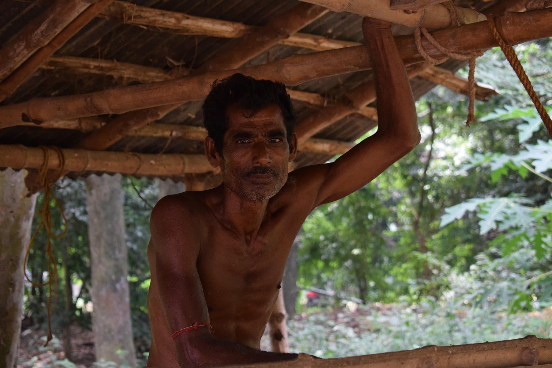 A rural worker beneath a traditional wooden structure